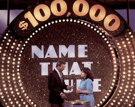 Image of host and contestant on Name That Tune television game show.